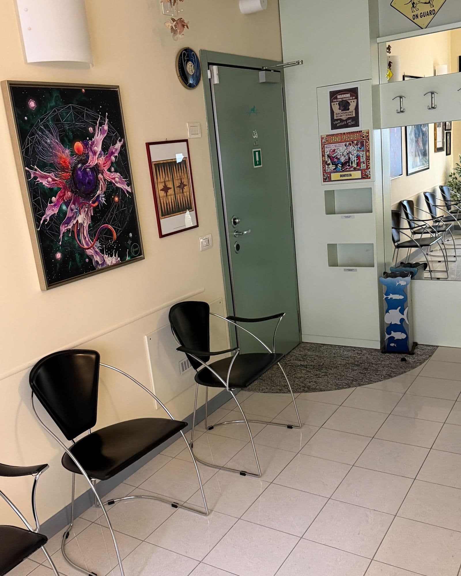 La sala d'attesa dello studio, con le sedute nere e i quadri alle pareti